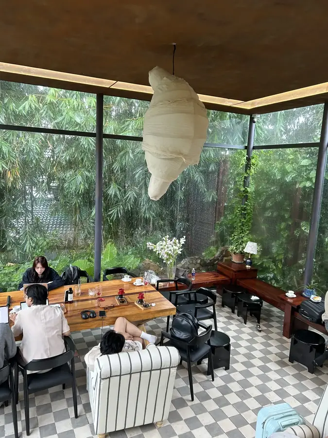 Стеклянный зал и лампа в форме круассана — Кофейня Croissant in Dalat — круассаны и кофе на чёрном чесноке, Далат