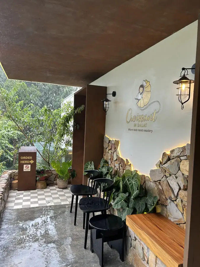 Вход во дворик с вывеской Croissant in Dalat — Кофейня Croissant in Dalat — круассаны и кофе на чёрном чесноке, Далат