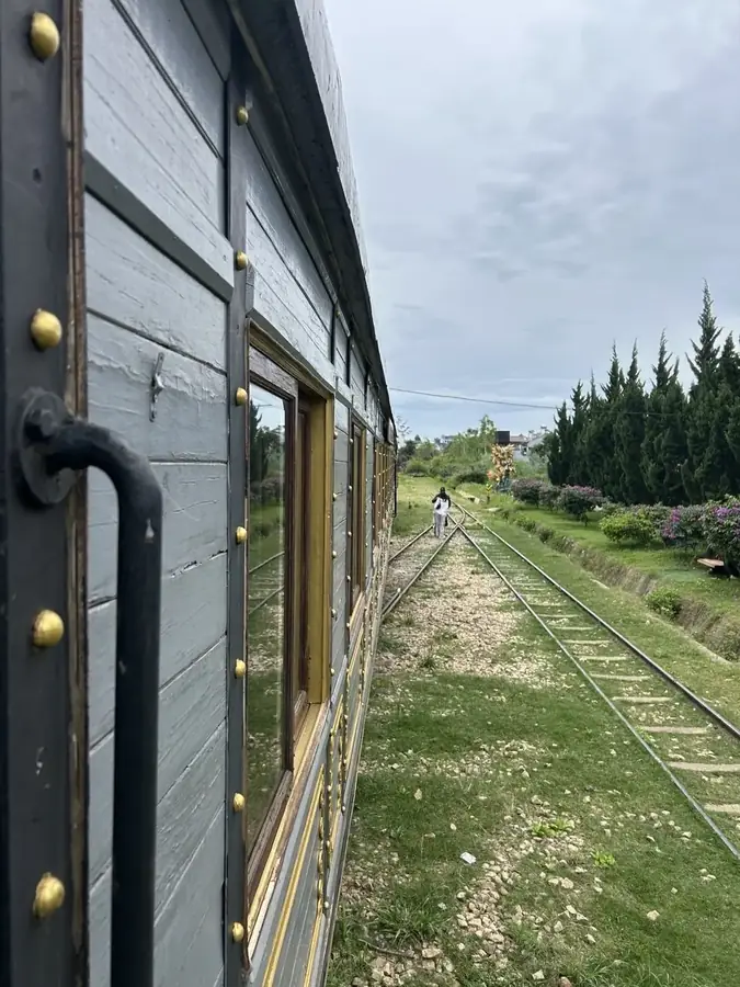 The track towards Trai Mat seen from the open carriage door — Trai Mat heritage train + pagoda, Da Lat