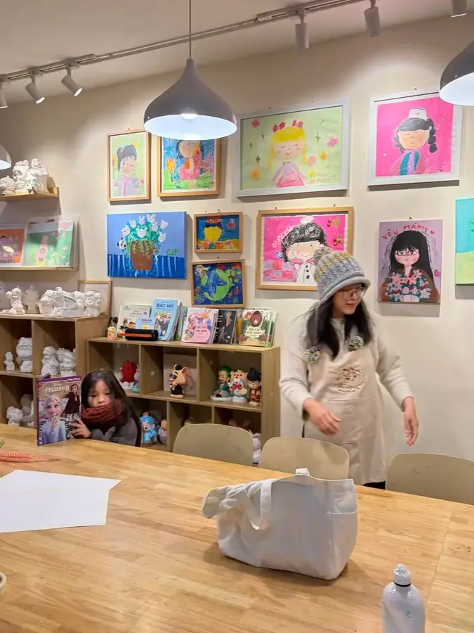 The shared table and the wall of pupils' work, Đảo Mộng Mơ — Đảo Mộng Mơ — a drawing studio for children, Da Lat