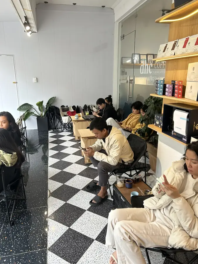 The room with its black-and-white harlequin floor and shelves of beans — dhc Coffee Lab — latte art and a barista school, Da Lat