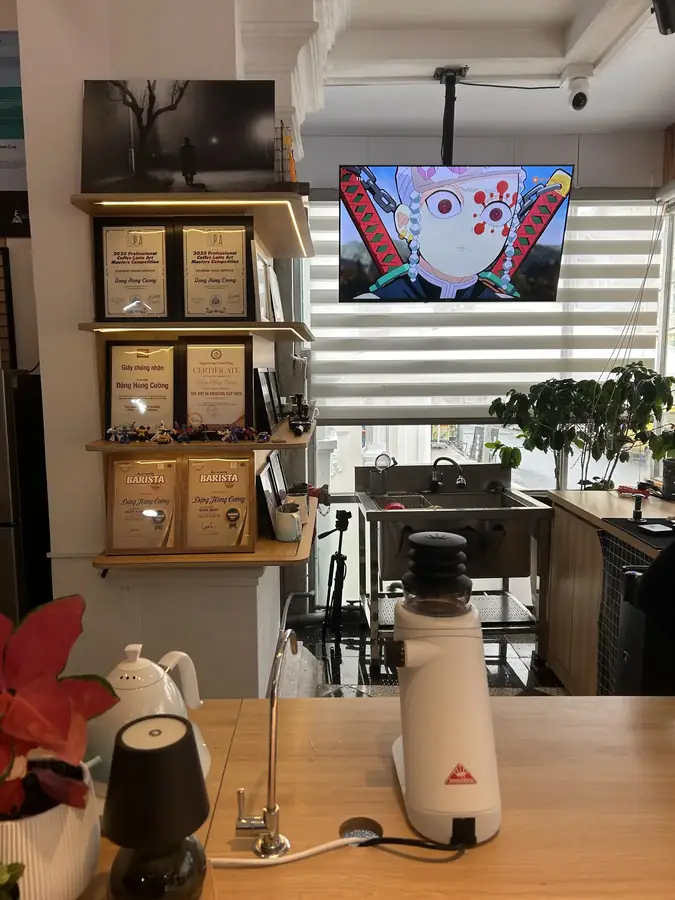 The counter with the grinder and the latte-art awards — dhc Coffee Lab — latte art and a barista school, Da Lat