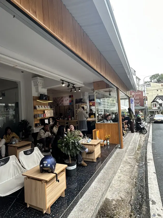 Tables on the pavement in front of the entrance — dhc Coffee Lab — latte art and a barista school, Da Lat