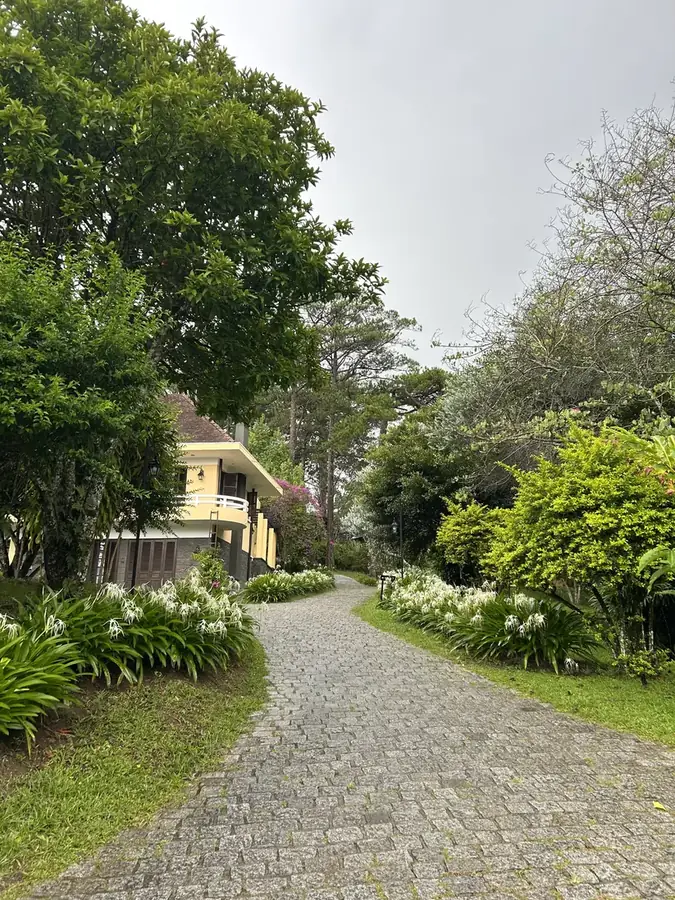 A cobbled lane along the villas, with garden beds and flowers — Ana Mandara Villas Dalat — French villas, a pool and a spa, Da Lat