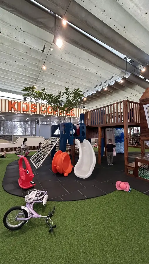 Slides, ride-ons and a climbing net on the covered playground — Kids Coffee — an indoor play room with a cafe, Da Lat