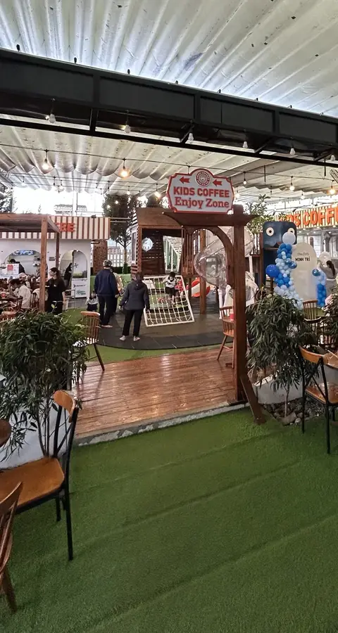 Daytime: the canopy over the playground, cafe tables and the Enjoy Zone sign — Kids Coffee — an indoor play room with a cafe, Da Lat