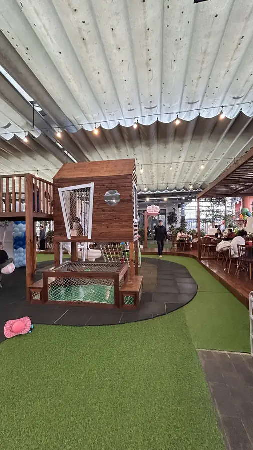 The wooden playhouse with netting, cafe tables all around — Kids Coffee — an indoor play room with a cafe, Da Lat