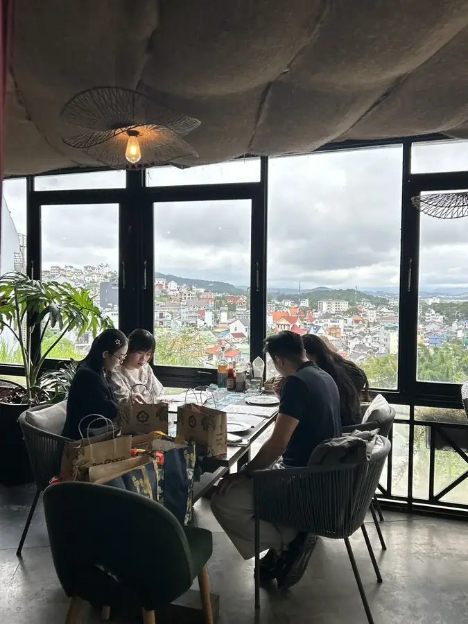 The upper room at Moto Laurie: full-height windows over the roofs of Da Lat