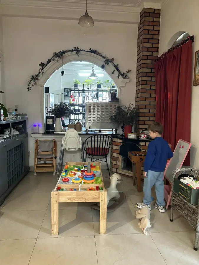 The kids' corner by the window: a low table with toys and a high chair — Moto Laurie — breakfasts and a vegan menu over the city, Da Lat